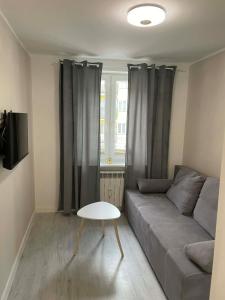 a living room with a couch and a table at Mazurski Apartment in Ełk
