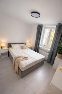 a bedroom with a large bed and a window at Mazurski Apartment in Ełk