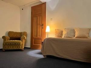 a bedroom with a bed and a chair and a door at Ferienwohnung Lukas in Frielendorf