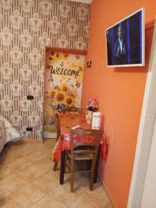 a dining room with a table and a picture on the wall at B&B JOY in Nettuno
