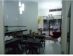 a dining room with tables and chairs in a room with a window at Hotel MM AEROPORTO BRASÍLIA in Núcleo Bandeirante