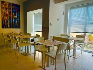 a dining room with tables and chairs and a painting at 8villa in St. Julianʼs