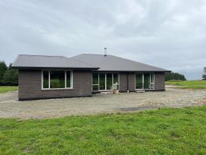 ein Backsteinhaus mit vielen Fenstern in der Unterkunft Shinness in Ashwick Flat