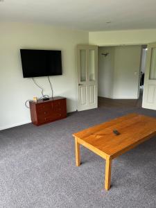 ein Wohnzimmer mit Couchtisch und Flachbildfernseher in der Unterkunft Shinness in Ashwick Flat