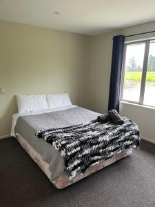 ein Schlafzimmer mit einem Bett, auf dem eine Decke liegt in der Unterkunft Shinness in Ashwick Flat