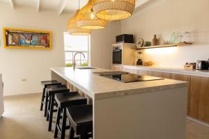 a kitchen with a large island with black bar stools at Nos Casita - 5 min walk to the beach in Pos Chiquito