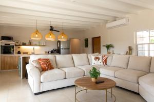 a living room with a white couch and a table at Nos Casita - 5 min walk to the beach in Pos Chiquito