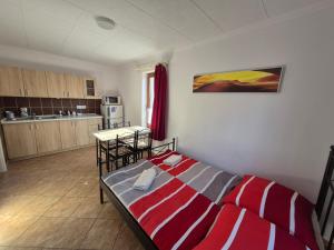 a bedroom with a red and white bed in a room at Flóra apartmanház a Balatonnál in Lovas