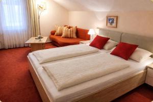 a hotel room with two beds and a couch at Pension Villa HarzFokus - Frühstück inklusive in Wernigerode