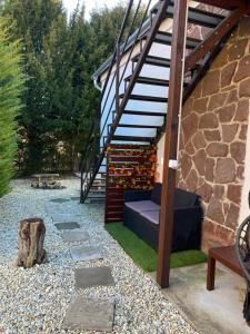 a garden with a bench and a stair case at Flóra apartmanház a Balatonnál in Lovas