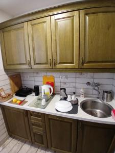 a kitchen with wooden cabinets and a sink at Apartamenty Polonia in Cserépfalu +46 photos