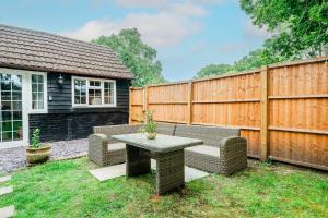 a backyard with a table and a fence at New Forest Cottage with Hot Tub, Fireplace and Private Garden in Cadnam +7 photos
