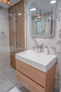 a bathroom with a white sink and a shower at Casa Frutta in Petrich +24 photos