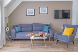 a living room with a blue couch and two chairs at Casa Frutta in Petrich