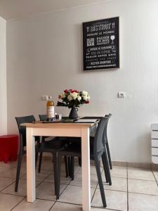 a dining room table and chairs with a vase of flowers at L'instant doré in Charnay +12 photos