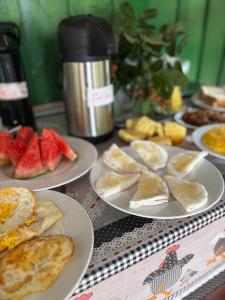 a table topped with plates of food and fruit at Flor da Mata in Iranduba +32 photos
