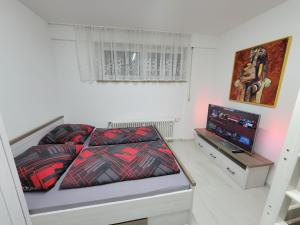 a bedroom with a bed and a flat screen tv at 3 WG-geeignete Zimmer zur Selbstverpflegung in Ostfildern +21 photos