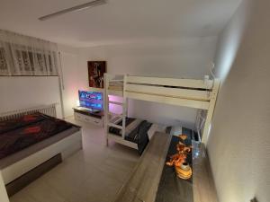 a bedroom with a bunk bed and a desk with a television at 3 WG-geeignete Zimmer zur Selbstverpflegung in Ostfildern