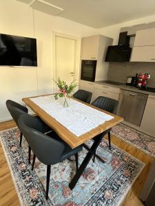 a dining room table with chairs and a kitchen at Ferienwohnung Blerta in Gerolstein