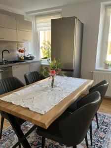 a kitchen with a table with a vase of flowers on it at Ferienwohnung Blerta in Gerolstein +10 photos