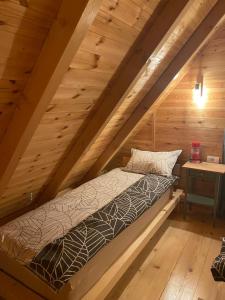 a bed in the attic of a log cabin at Brvnara Zoja - Zlatar in Prorečane