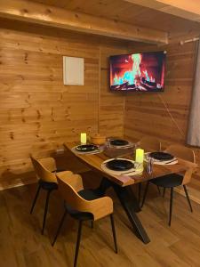 a dining room with a table and chairs and a tv at Brvnara Zoja - Zlatar in Prorečane