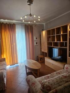 a living room with a couch and a table and a tv at Sunny And Waves Apartment in Golem
