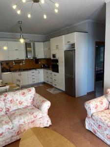 a living room with two couches and a kitchen at Sunny And Waves Apartment in Golem +9 photos