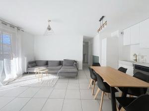 a white living room with a table and a couch at Appartement cosy à Bron in Bron