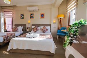 a hotel room with two beds and a blue chair at Ada Olympos Otel in Bozcaada