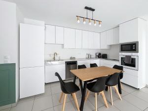 a kitchen with a wooden table and black chairs at Appartement cosy à Bron in Bron +9 photos