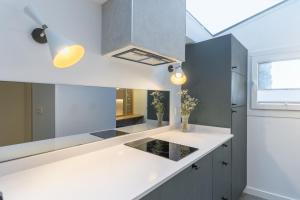 a kitchen with a white counter top and a window at SEBASTIAN Apartamentos in Getaria +11 photos
