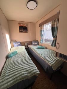 two beds in a small room with a window at Seaton Sands 71 Aberlady in Port Seton +12 photos