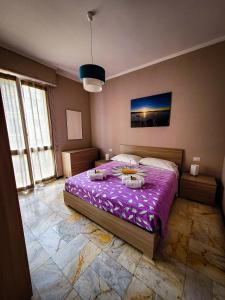 a bedroom with a large bed with purple sheets at Alloggio Rumore di Onde in Rapallo