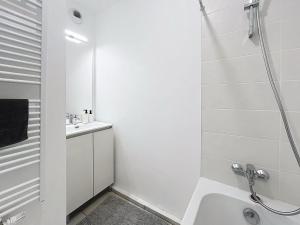 a white bathroom with a shower and a sink at Appartement cosy à Bron in Bron