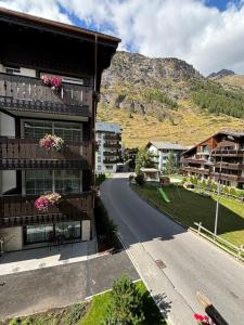 una casa con fiori sui balconi di una strada di Chalet Medi a Zermatt