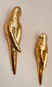 two gold birds earrings hanging on a wall at Finca W - Coín - Málaga - Andalucía in Coín