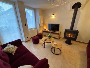 a living room with a couch and a fireplace at La Parenthèse Sancerroise in Savigny-en-Sancerre