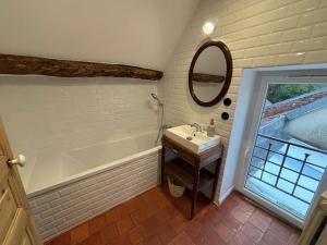 a bathroom with a tub and a sink and a mirror at La Parenthèse Sancerroise in Savigny-en-Sancerre