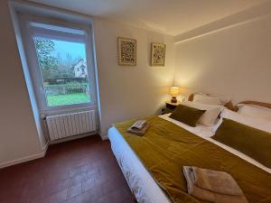 a bedroom with a large bed and a window at La Parenthèse Sancerroise in Savigny-en-Sancerre