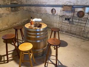 a bar with stools and a bottle of wine in a barrel at La Parenthèse Sancerroise in Savigny-en-Sancerre