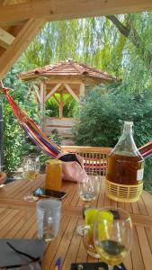 a wooden table with glasses of wine and a bottle at Apartamenty Polonia in Cserépfalu