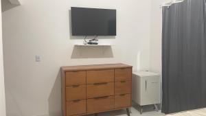 a tv on a wall with a dresser and a dresser at Casa do Val in Fernando de Noronha