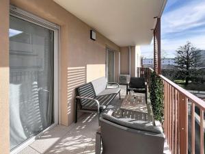 a balcony with two chairs and a table on a balcony at Appartement cosy à Bron in Bron