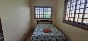 a small bedroom with a bed with a blue and whitespread at Canto dos Pássaros in Brasília