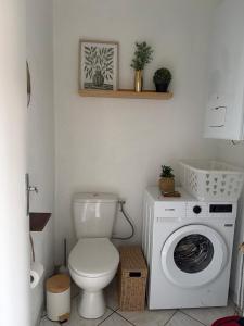 a bathroom with a toilet and a washing machine at Appartement Maisonnette pour 4 personnes in La Ferté-Vidame