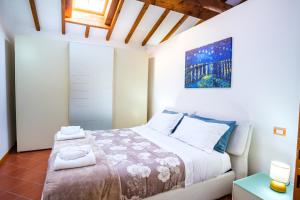a bedroom with a bed and a painting on the wall at La Dolce Imola-Bilocale in centro storico in Imola