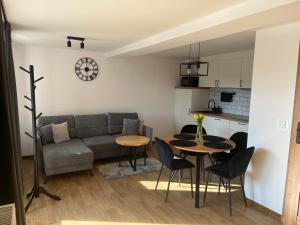 a living room with a couch and a table and chairs at Apartament Górska Przystań Kluszkowce in Kluszkowce