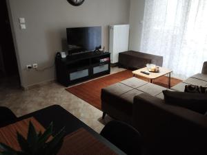 a living room with a couch and a flat screen tv at Gianis Homme in Alexandroupoli
