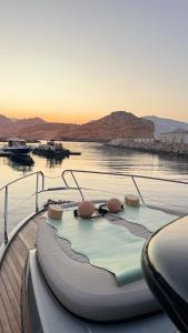 a boat sitting in the water with the sun setting at MYTH bay in Bandar Jişşah